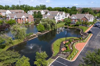 An aerial view of a pond with houses in the background